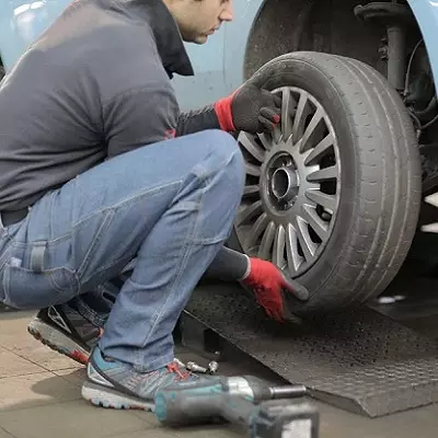 Mecánico cambiando rueda de auto