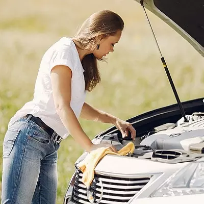 Mujer revisando el motor de un auto