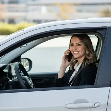 Mujer hablando por teléfono sentada en el auto